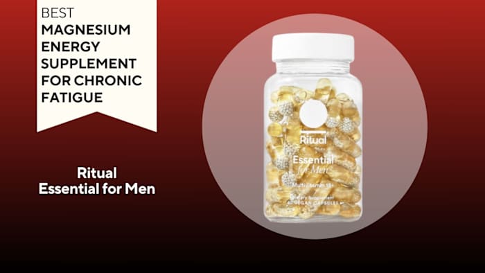 Clear pill bottle filled with yellow pills against a red background